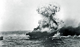 A devastating explosion rocks USS Lexington as torpedoes stored belowdecks detonate. The carrier USS Yorktown can be seen on the horizon in the distance. (US Navy)